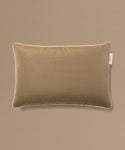 Brown pillow with a brand tag on a beige background