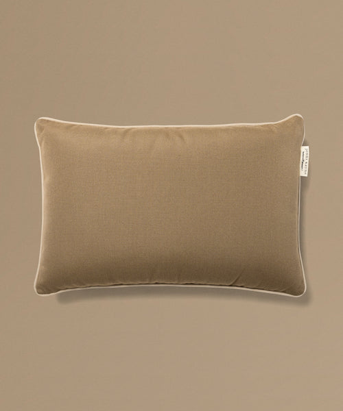 Brown pillow with a brand tag on a beige background