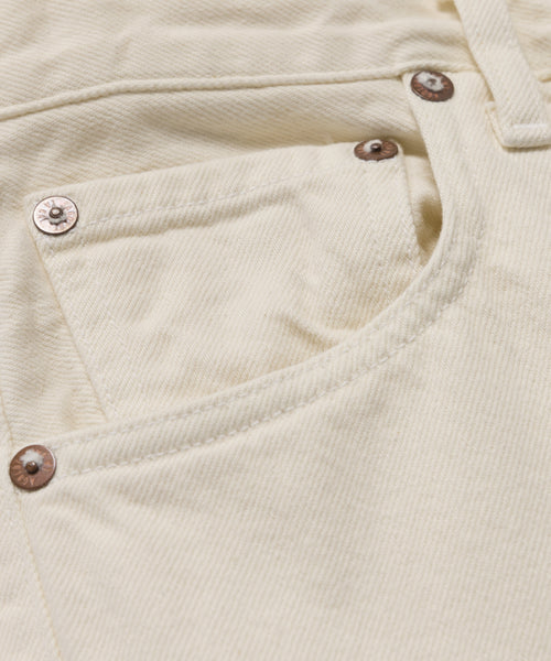 Close-up of the Ren jean’s pocket in cream, crafted from regenerative cotton with visible stitching and copper rivets at the corners.