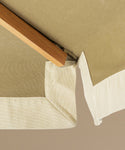Green patio umbrella with a wooden handle on a beige background