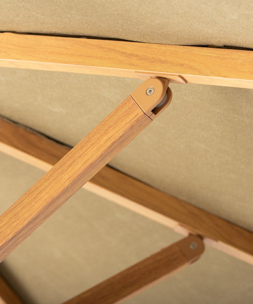 Green patio umbrella with a wooden handle on a beige background