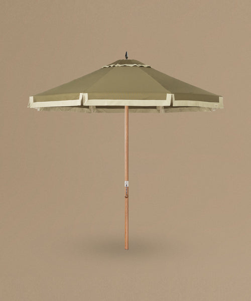 Green patio umbrella with a wooden handle on a beige background