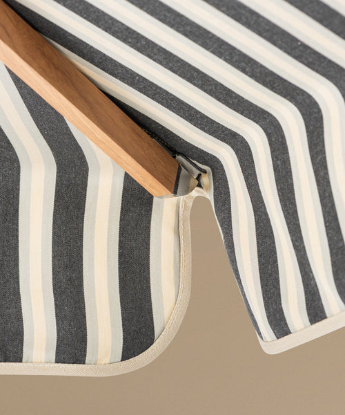Close-up of a striped fabric umbrella on a beige background