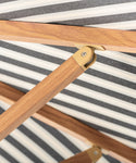 Wooden folding umbrella with metal joints on a striped fabric background
