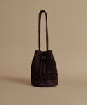 Brown woven handbag on a beige background
