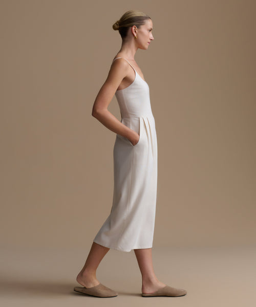 Woman wearing a white dress against a beige background