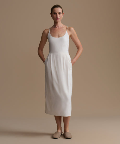 Woman wearing a white dress against a beige background