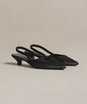 The Satin Kitten Heel, an elegant pair of black satin slingbacks with pointed toes and kitten heels made in Italy, is showcased on a light neutral background.