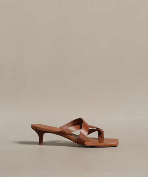 The Scarlett Heeled Sandal features brown leather, a low kitten heel, crisscross straps, and a square toe—displayed on a neutral background, it’s the ideal sunshine-approved summer footwear.