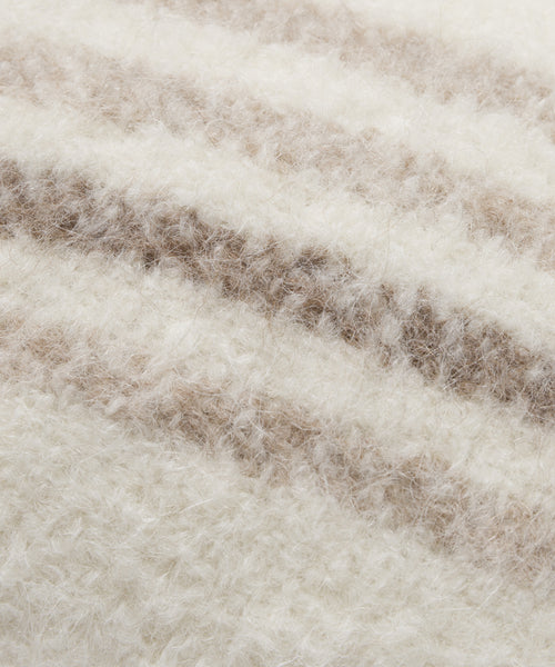 Close-up of the Sheridan Pillow’s soft, textured fabric with cream and light brown horizontal stripes. Thick, woolly fibers resemble alpaca blend yarn, giving this pillow a warm and cozy look.