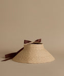 Woven sun visor with a brown ribbon on a beige background
