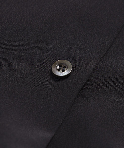Close-up of a single black button sewn onto the Silk Sloane Shirt, featuring textured black fabric and a relaxed fit.