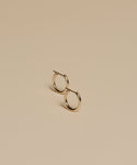 The Small Eloise Hoops, crafted from 14k gold by Jenni Kayne, are displayed slightly apart on a plain beige surface with soft lighting and minimal shadows.