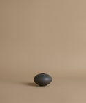 Black ceramic vase on a beige background