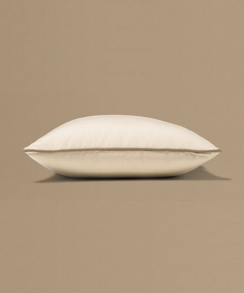 Beige pillow with a tag on a beige background