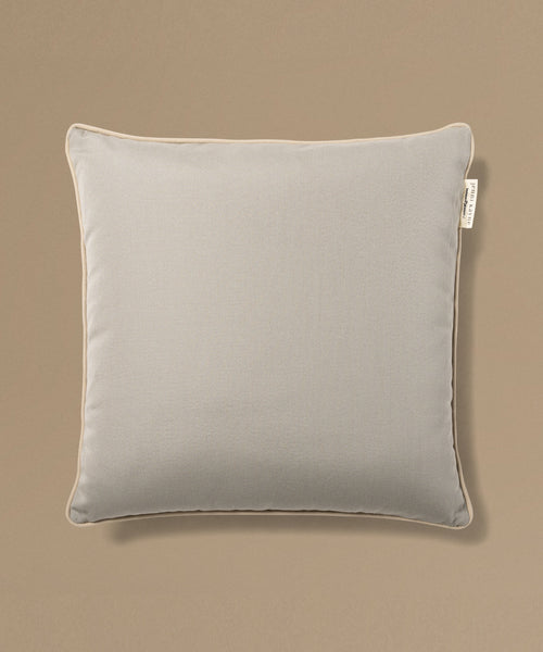 Gray pillow with a brand tag on a beige background