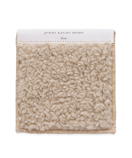 A square beige Fabric Swatch Bone Sherpa with a thick, looped texture. The white label reads Jenni Kayne Home and Bone, making it a perfect match for the Aspen Sofa or Bone Sherpa collection.