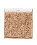 The Fabric Swatch Oatmeal Sherpa is a square sample in light beige with a plush, textured loop pile, reminiscent of cozy oatmeal sherpa. A white top label reads jenni kayne home Oatmeal.