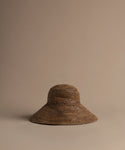 Chocolate soleil hat on a beige background