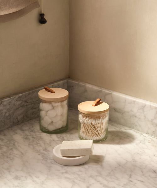 Glass canisters in a bathroom. 