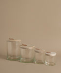 Glass canisters against a beige background.