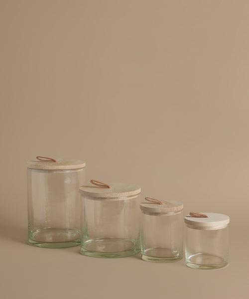 Glass canisters against a beige background.