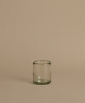 Recycled glass cup against a beige background.