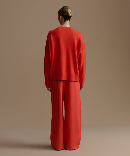 Woman wearing a red outfit against a beige background