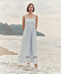Woman wearing a light blue dress at the beach. 