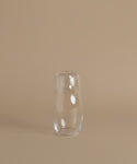 A glass carafe against a beige background.