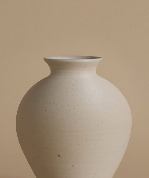 White ceramic vase on a beige background