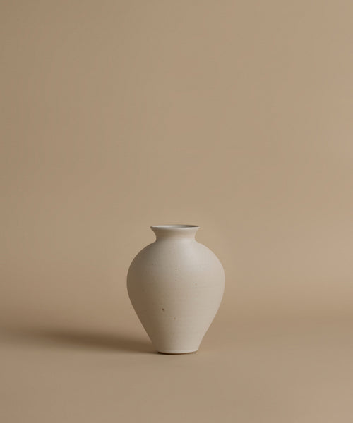 White ceramic vase on a beige background