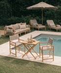 Outdoor patio set with furniture and table by a pool