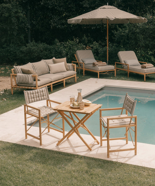 Outdoor patio set with furniture and table by a pool