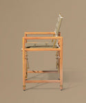Foldable chair with wooden frame and beige cushion on a brown background
