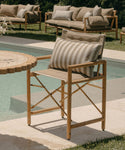 Wooden outdoor chair with striped cushion near a poolside setting
