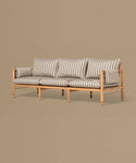Wooden sofa with striped cushions on a beige background