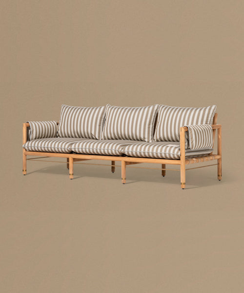 Wooden sofa with striped cushions on a beige background
