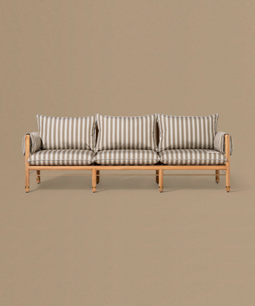Wooden sofa with striped cushions on a beige background