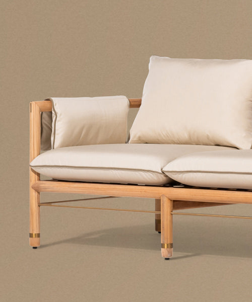 Beige sofa with wooden frame against a beige wall
