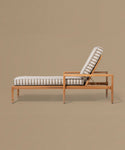 Wooden lounge chair with striped cushion on a beige background