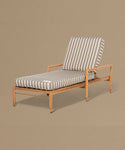 Wooden lounge chair with striped cushion on a beige background