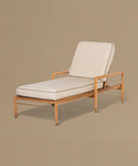 Beige lounge chair with white cushions on a beige background