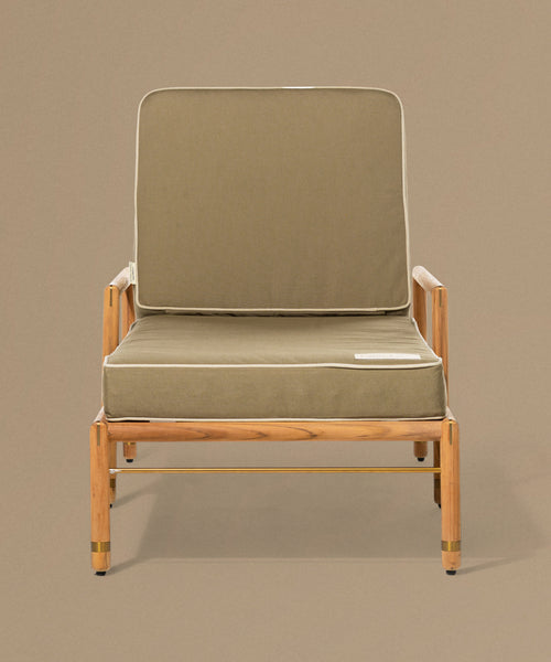 Lounge chair with green cushion on a beige background