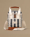 Striped cooler bag with leather accents on a beige background