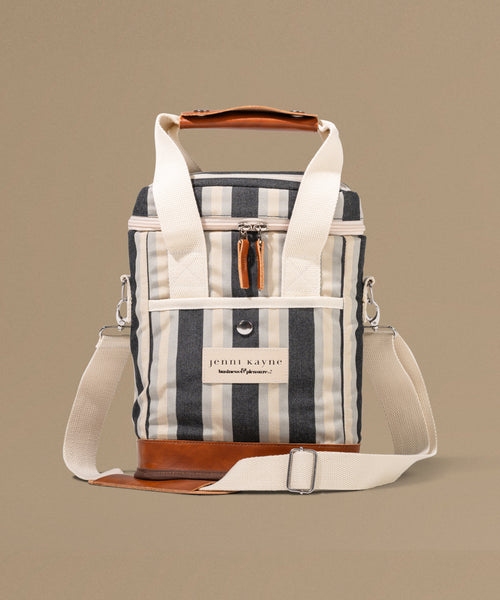 Striped cooler bag with leather accents on a beige background