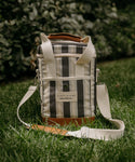 Striped cooler bag with leather accents on grass