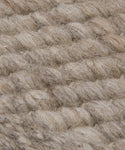 Close-up of a woven, chunky beige and light brown wool fabric with visible fibers and textured braids, similar to a Rug Swatch in warm walnut tones.