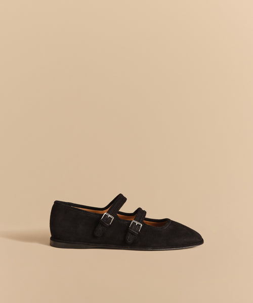 The Wren Flat is a black Mary Jane shoe featuring double straps and a sleek, pointed toe.