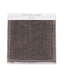 A square Fabric Swatch Ash Linen with visible white stitching and a textured, dark grayish-brown linen material designed to complement the Sunset Dining Arm Chair.
